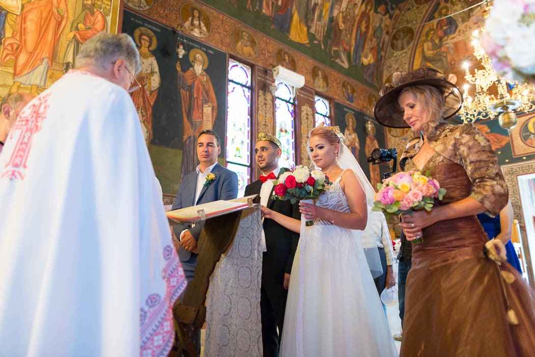 Rolul nasilor la cununia religioasa, mirii si nasii in mijlocul slujbei, preotul citeste rugaciunile, mireasa si nasa cu buchetele in mana
