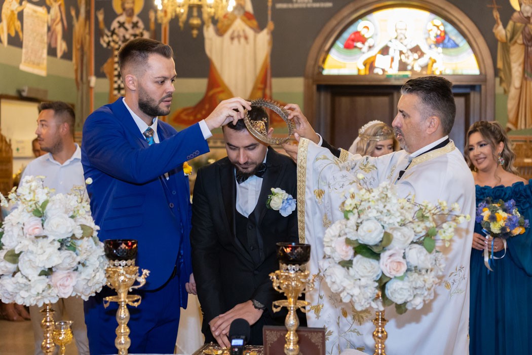Nasul cu preotul scoate cununa imparatesca de pe capul mirelui, nasa cu mireasa in fundal